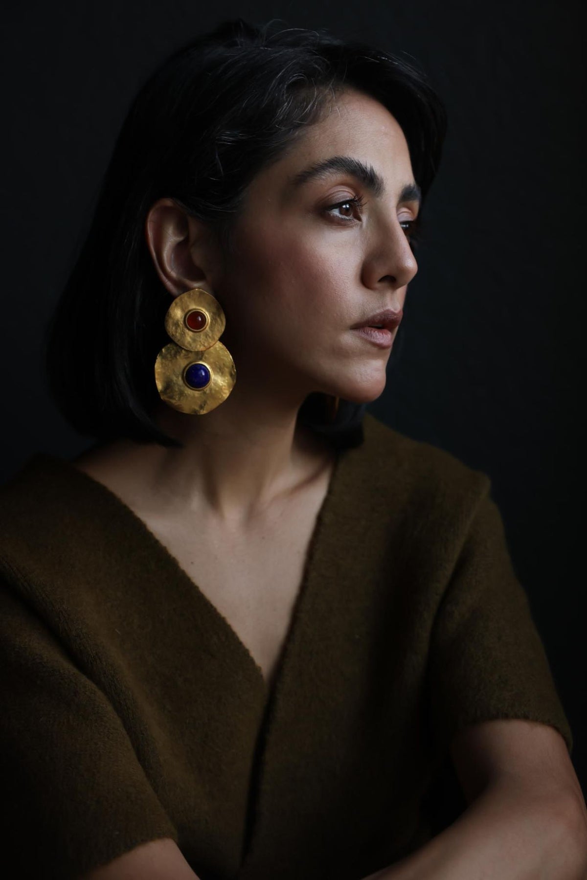 Model wearing oversized Les Bernard style gold disc statement earrings