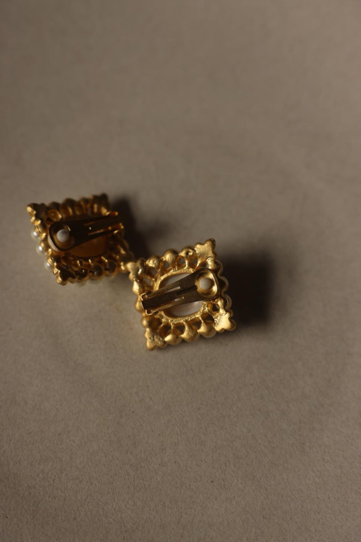 Back of the square gold tone earrings showing clip-on closures