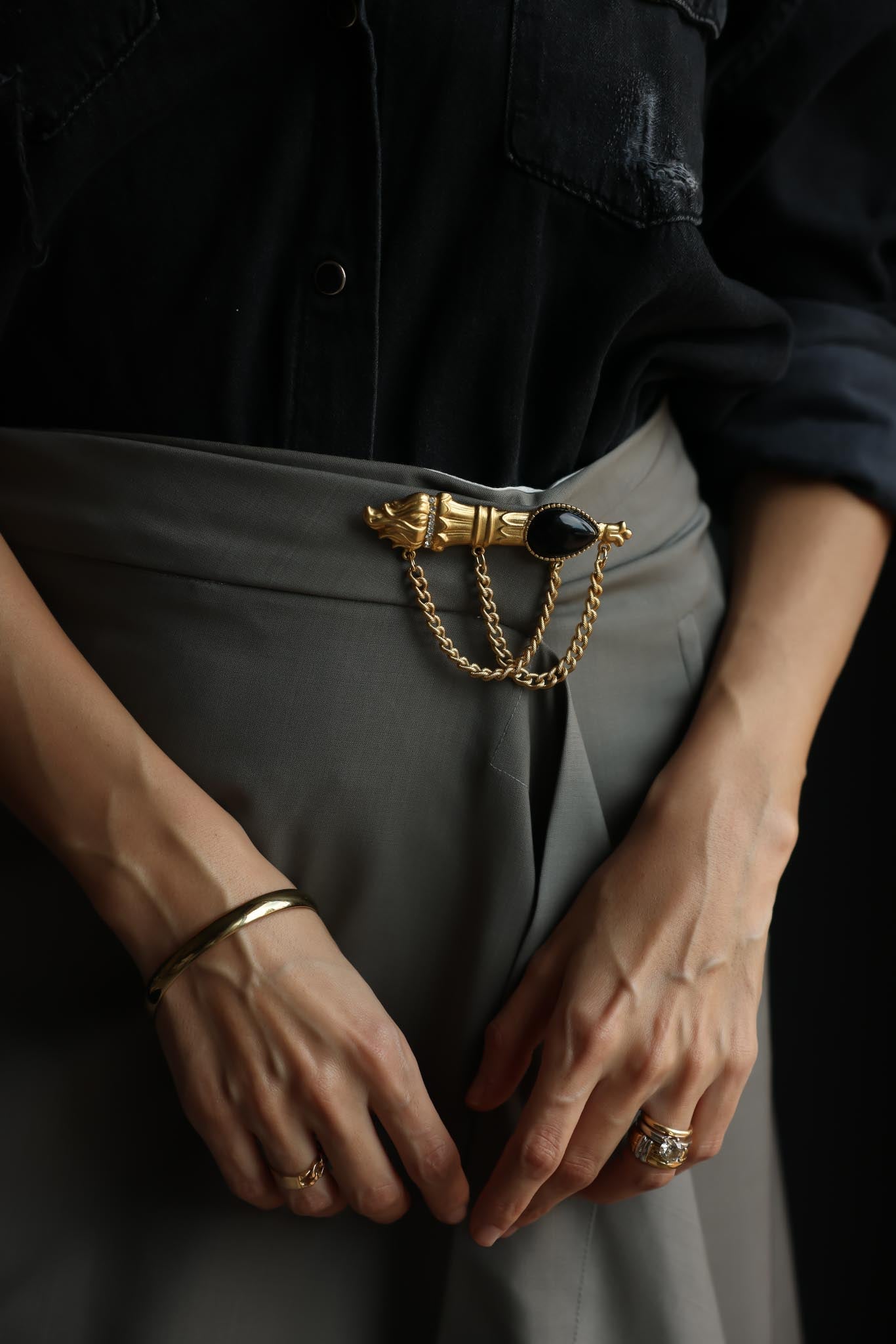 Matte Gold-Tone Draped Chain Brooch with Black Teardrop Center