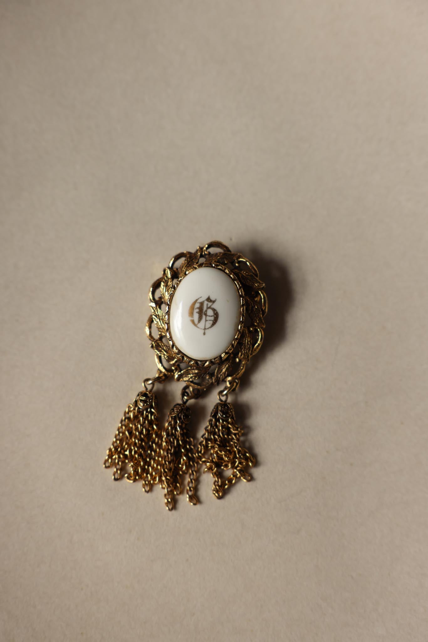 Gold Tone Monogram Tassel Brooch