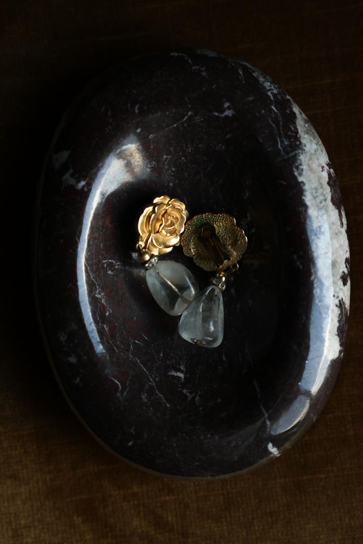 Front and clip-on back of gold plated rose earrings showing green discoloration on the back